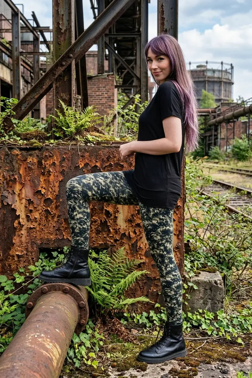 Frau trägt gemusterte Leggings aus Baumwolle in urbaner Industrielandschaft, nachhaltig produziert