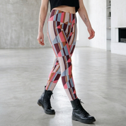 Frau mit bunter, gemusterter Baumwoll-Leggings und schwarzen Boots in modernem, hellen Raum
