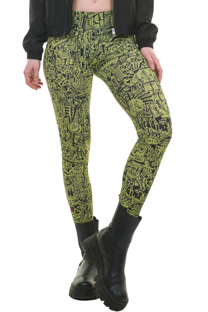 Frau trägt gelb-schwarze Leggings mit abstraktem Muster und Stiefeln, nachhaltige Mode