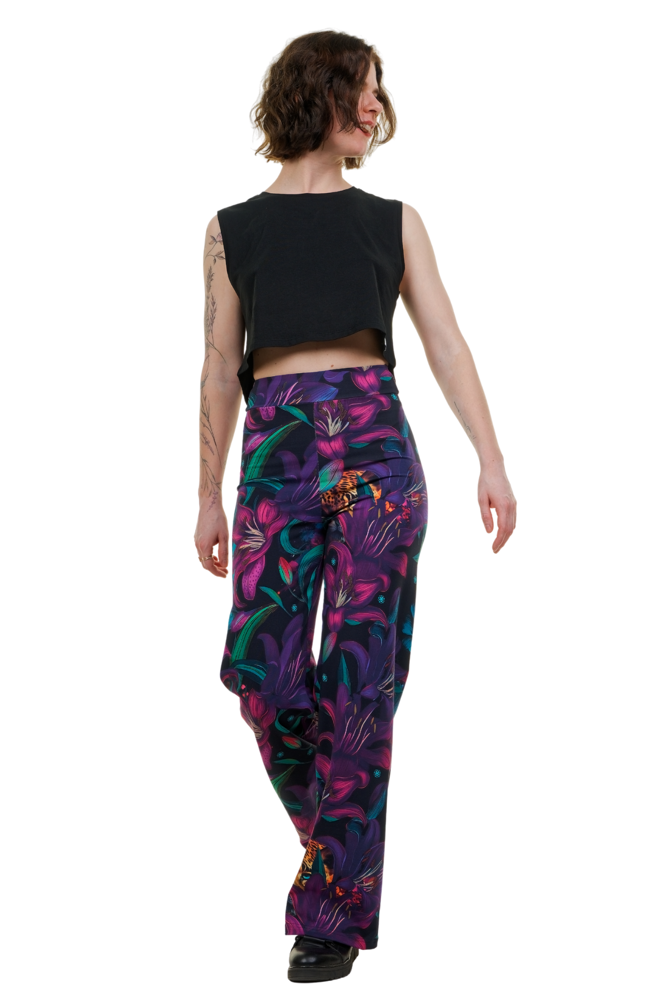 Frau trägt Marlenehose aus Baumwolle mit buntem, floralen Muster und schwarzem Top
