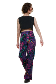 Frau trägt Marlenehose aus Baumwolle mit buntem, floralen Muster und schwarzem Top