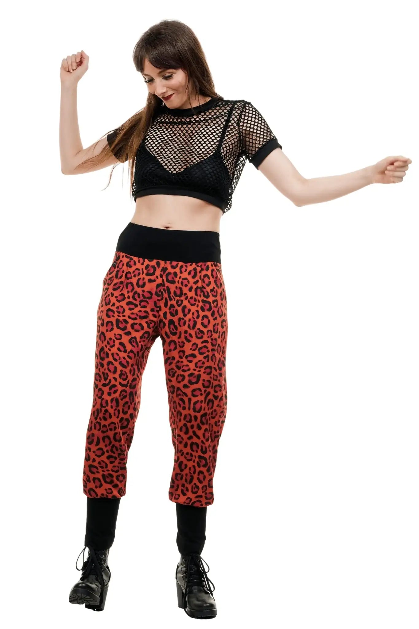 Frau trägt nachhaltige Baggy-Hose mit rotem Leo-Muster und schwarzem Bündchen, Modestil.