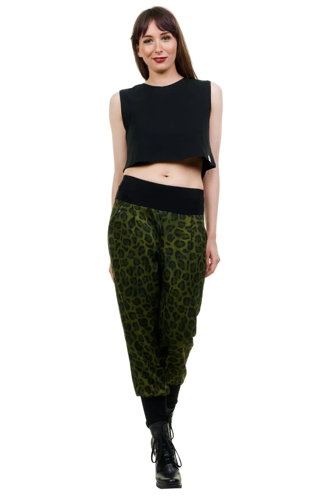 Frau trägt nachhaltige Baggy-Hose mit grünem Leopardenmuster, schwarzem Bund und schwarzem Top.