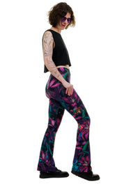 Frau mit bunten Schlagleggings im floralen Muster, schwarzes Top, Tattoos, nachhaltige Mode