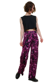Frau trägt weite Hose mit pinkem Blumenmuster, kombiniert mit schwarzem Crop-Top