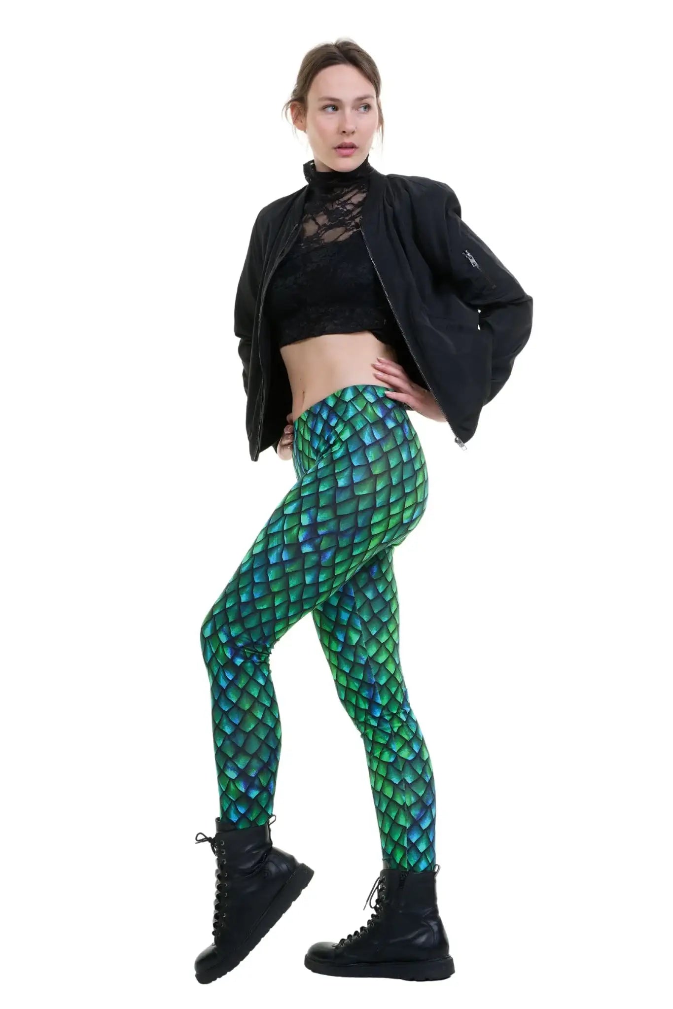 Frau in grüner Leggings mit Schuppenmuster, schwarzer Spitze und Jacke, Modemode