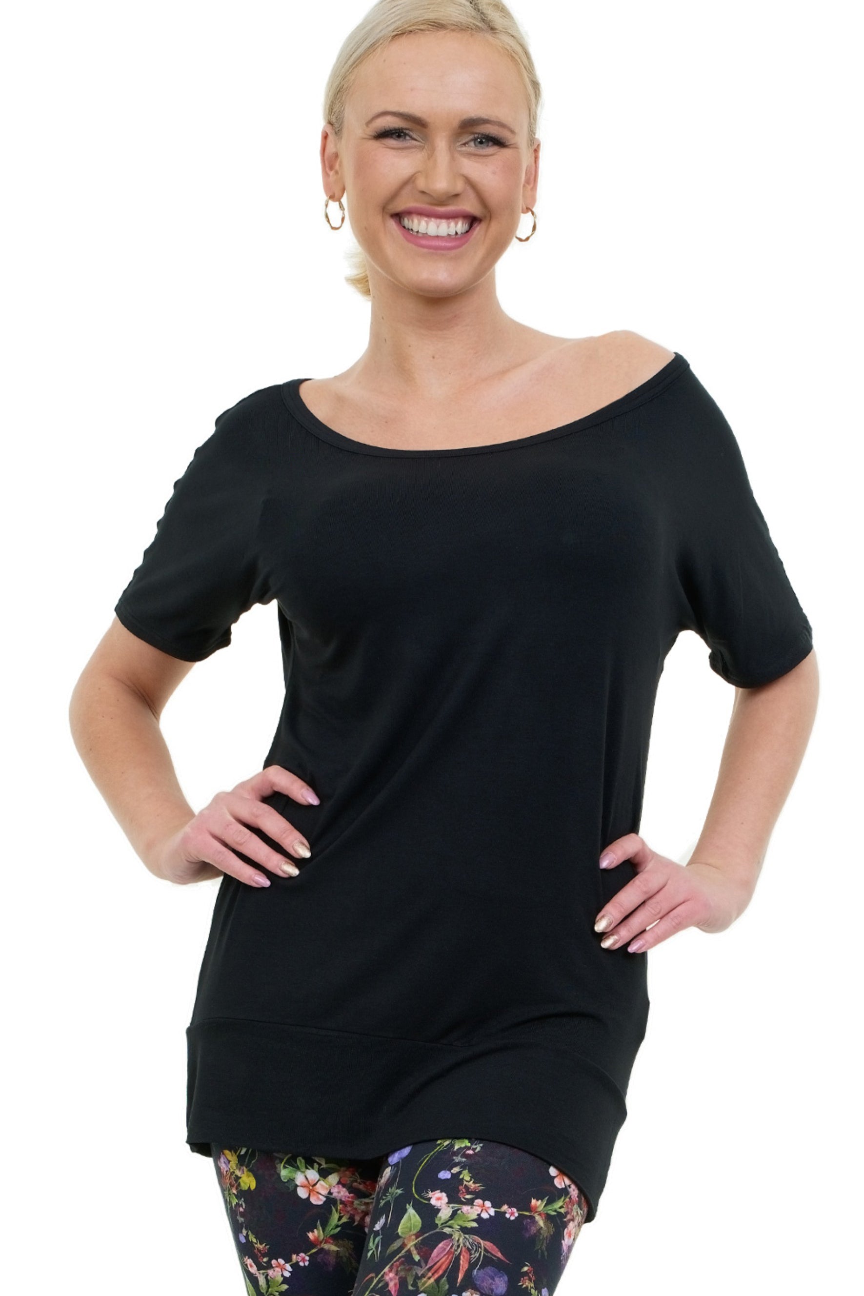 Frau trägt das Shortdress Curlix in Schwarz als Tunika kombiniert mit gemusterter Leggings – Nachhaltige Mode aus Berlin.