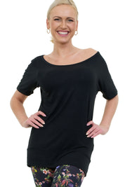 Frau trägt das Shortdress Curlix in Schwarz als Tunika kombiniert mit gemusterter Leggings – Nachhaltige Mode aus Berlin.