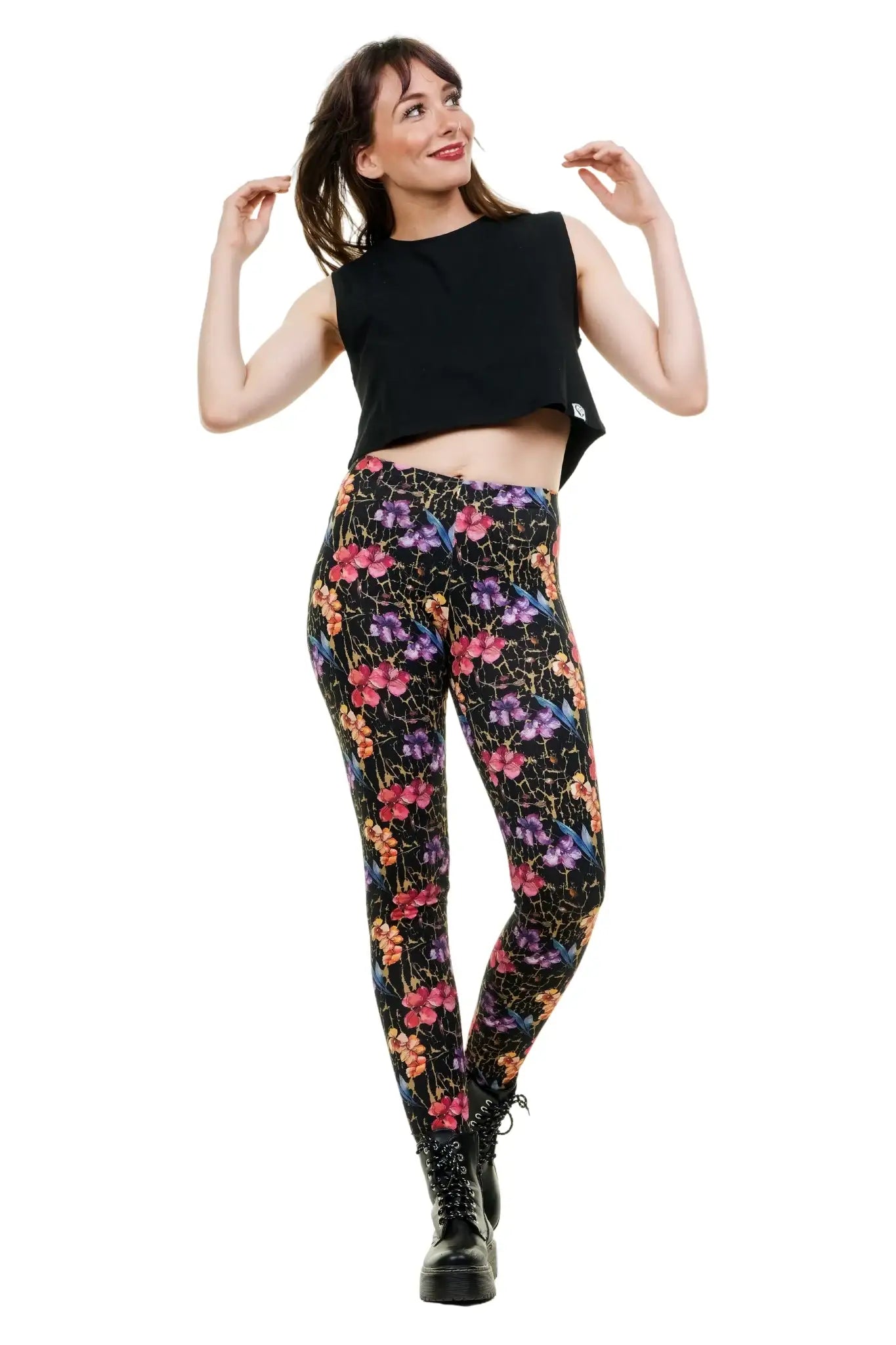 Frau trägt schwarze Leggings mit buntem Blumenmuster und schwarzes Crop-Top, handgefertigt in Berlin aus Baumwolle