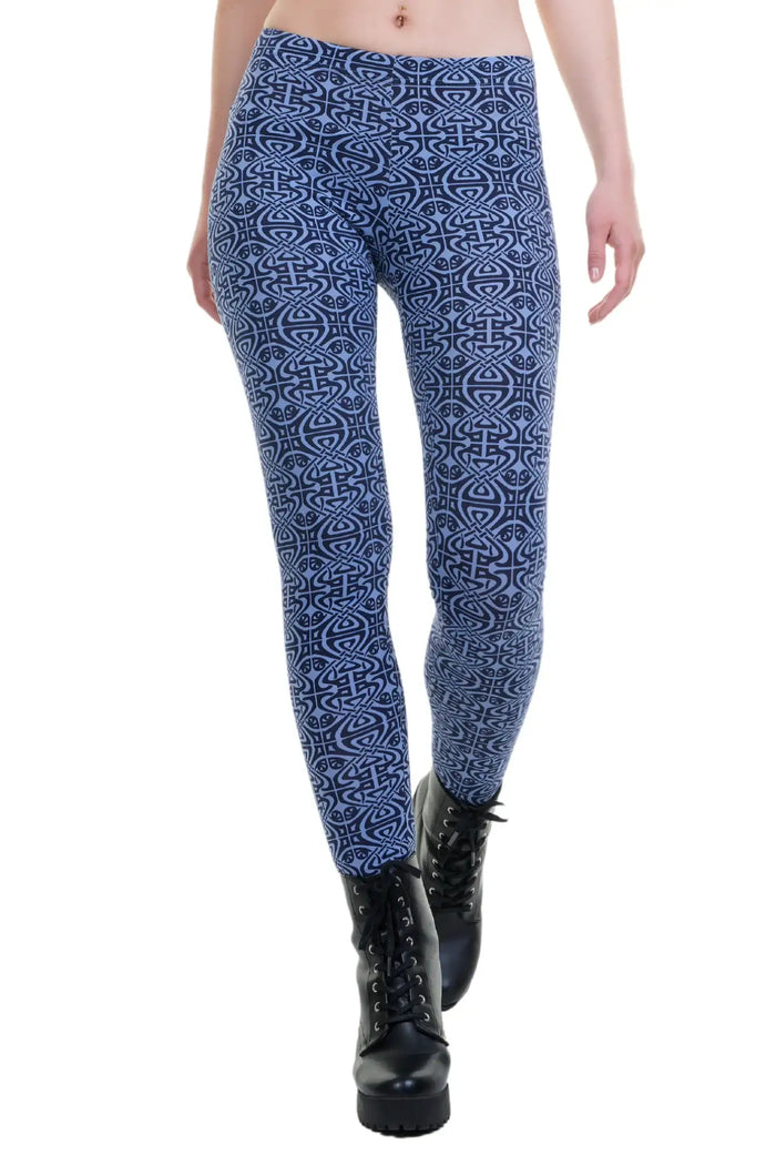Blaue Leggings mit abstraktem Muster, getragen zu schwarzen Stiefeln, auf weißem Hintergrund