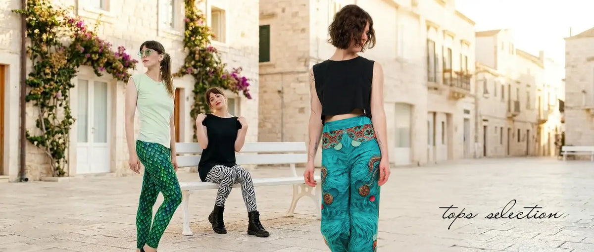 Drei Frauen tragen farbenfrohe Baumwoll-Leggings und Oberteile in heller Altstadt.