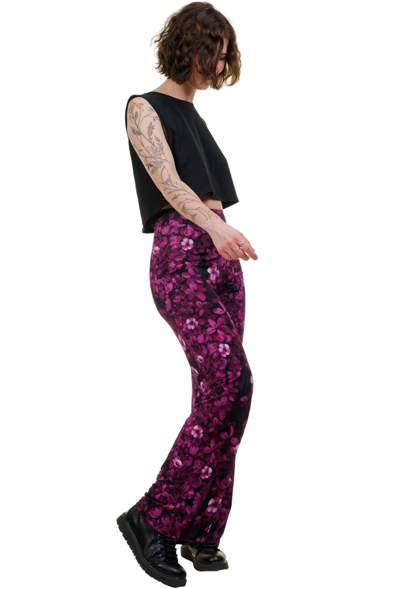 Frau trägt Marlenehose mit pinkem Blumenmuster und schwarzes Crop-Top, seitliche Ansicht