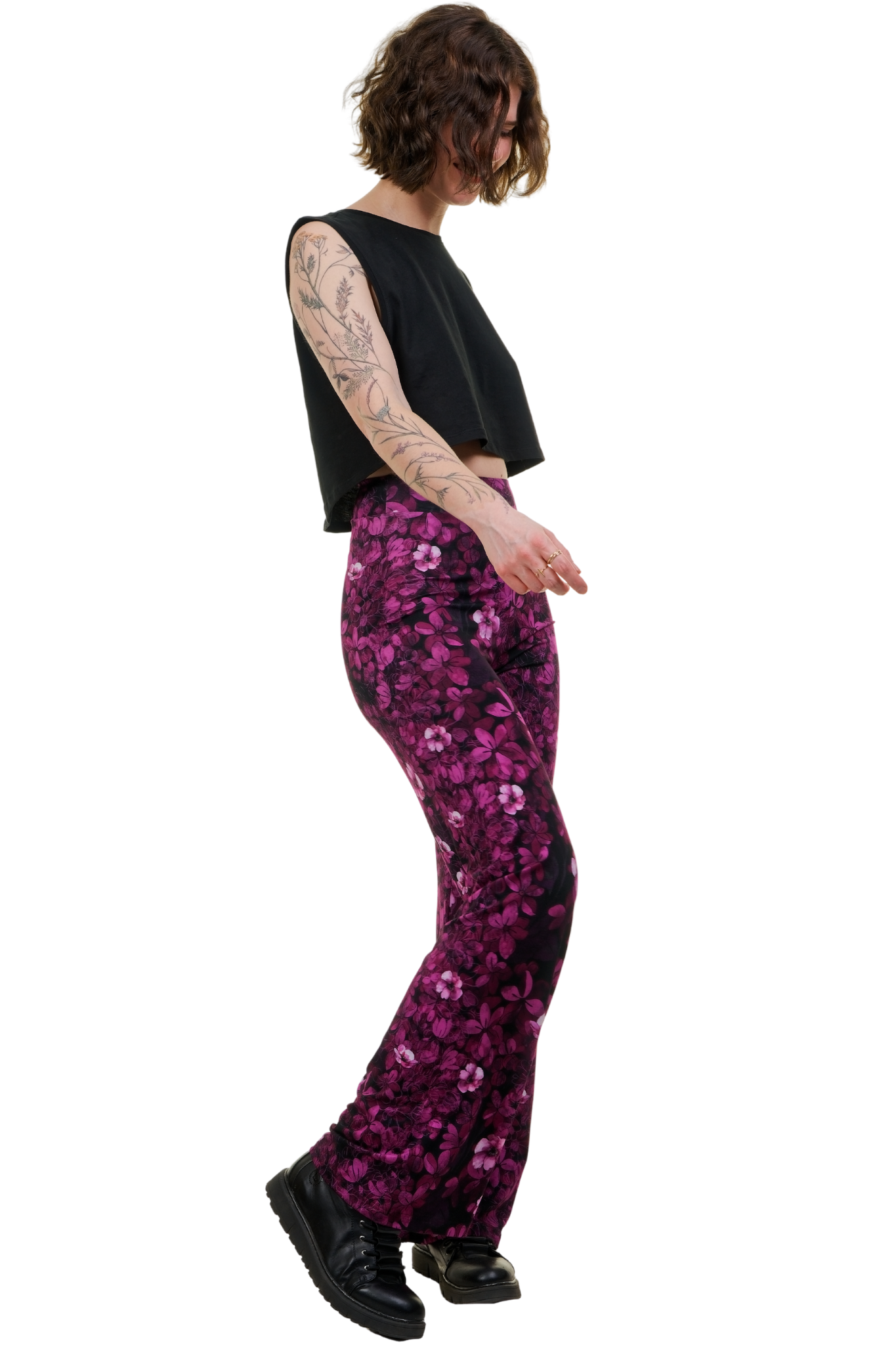 Frau trägt Marlenehose mit pinkem Blumenmuster und schwarzes Crop-Top, seitliche Ansicht