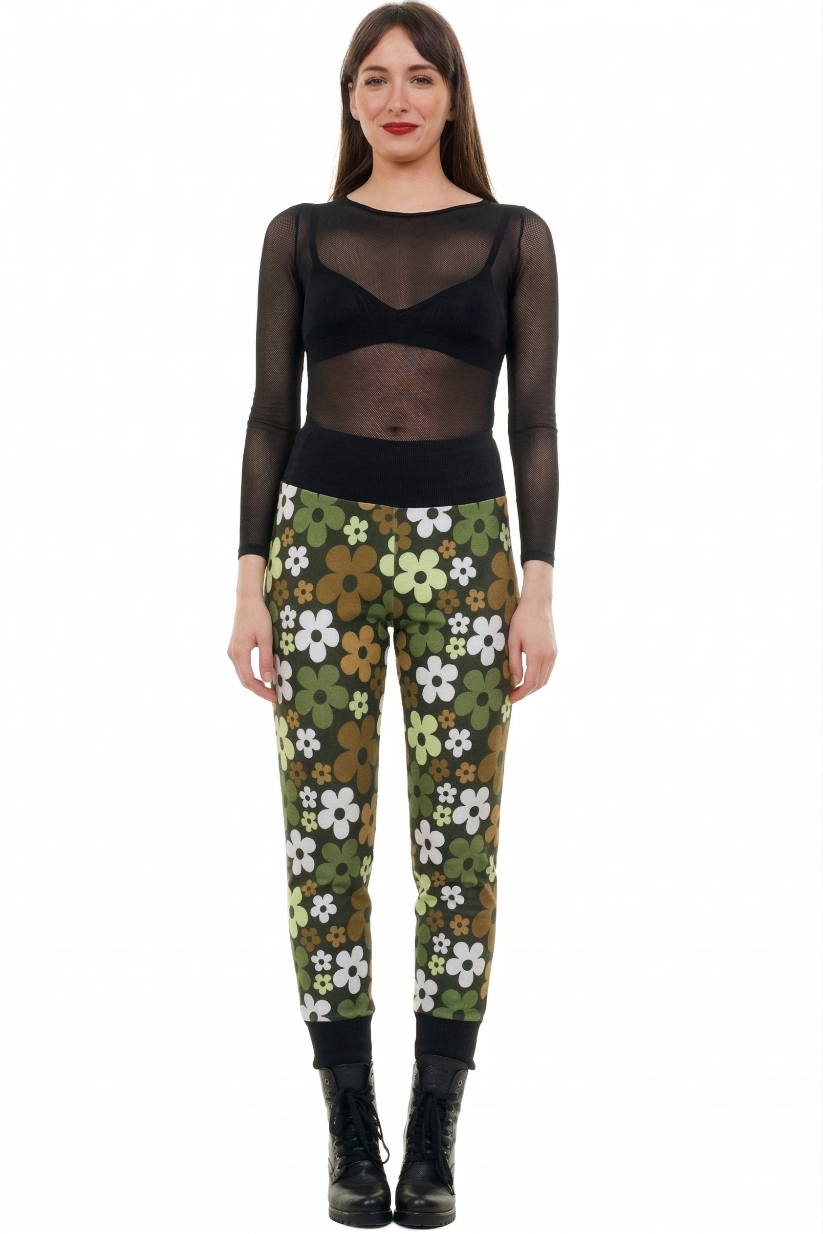 Frau trägt olivegrüne Retro-Blumenhose mit buntem Blumenmuster und schwarzem Oberteil