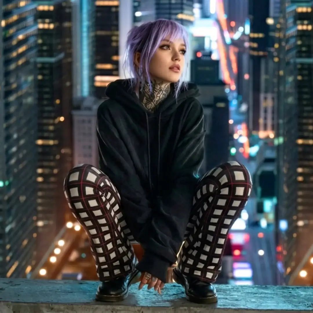 Frau mit ausgefallenen Schlagleggings mit Taschen aus Baumwolle, sitzt auf Hochhausdach in der Stadt