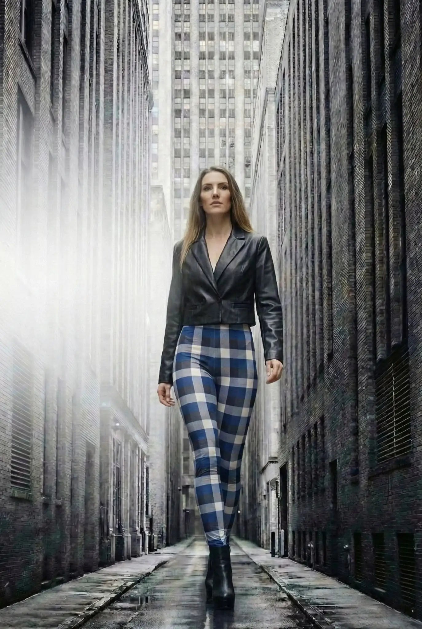 Frau in blauen Karomuster-Leggings und schwarzer Lederjacke läuft durch urbane Gasse