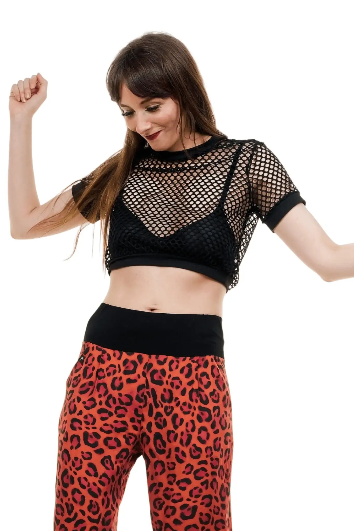 Frau mit schwarzem Netzshirt und roter Haremshose mit Leopardenmuster, sommerliches Damen Outfit