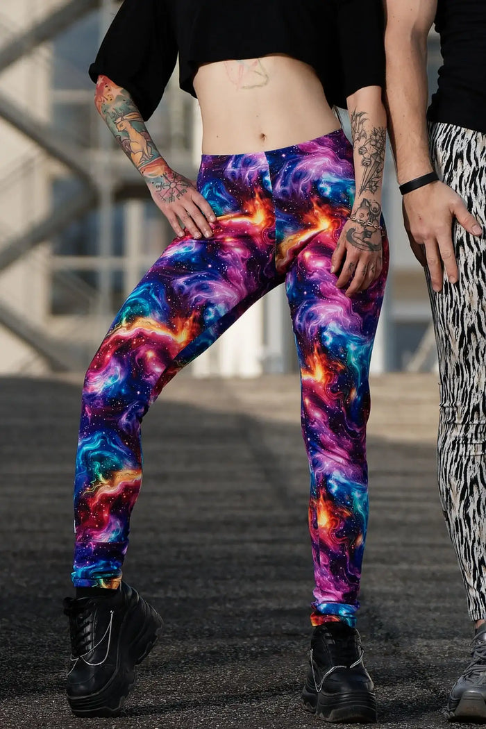 Bunte Leggings mit Galaxie-Print aus Baumwolle, getragen von tätowierter Person im Freien