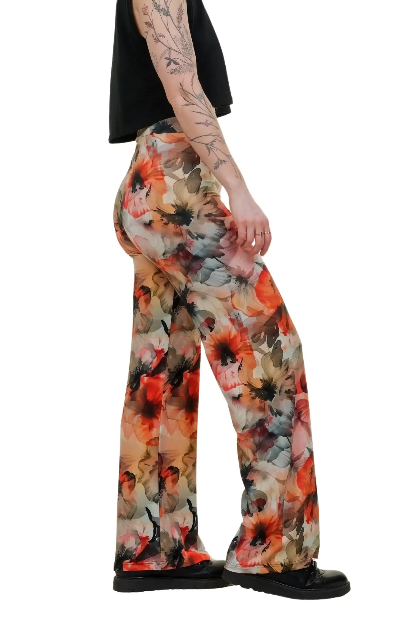 Weite Damenhose mit buntem Blumenmuster aus Baumwolle, getragen von Person in Schwarz-Oberteil